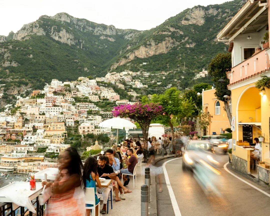 People dine at a restaurant overlooking a coastal town.